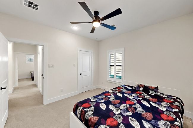 Bedroom with multiple windows, light colored carpet, baseboards, and a ceiling fan | Image 23