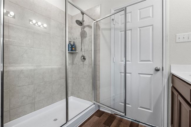 Bathroom featuring laminate / wood-style flooring, a walk-in shower with door | Image 24