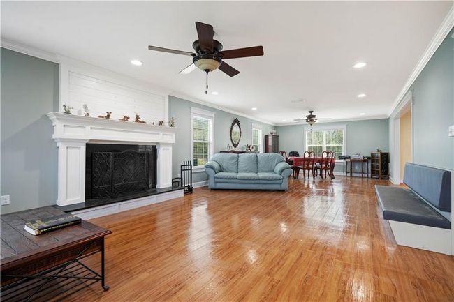 Living area with plenty of natural light, light wood-style floors, and ceiling fan | Image 7
