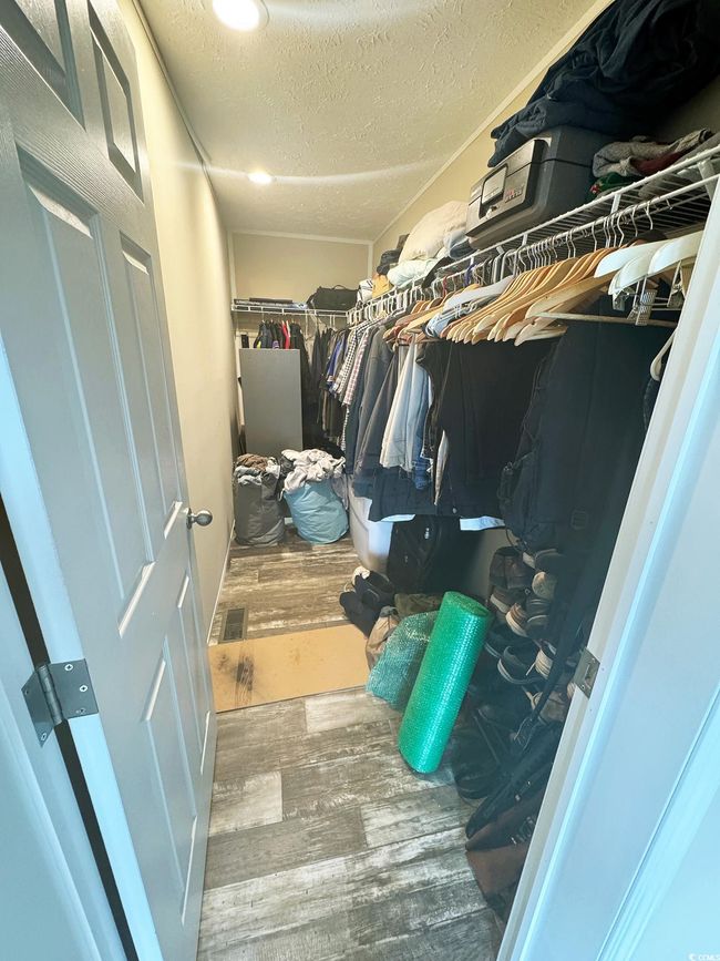 Walk in closet featuring wood finished floors | Image 21