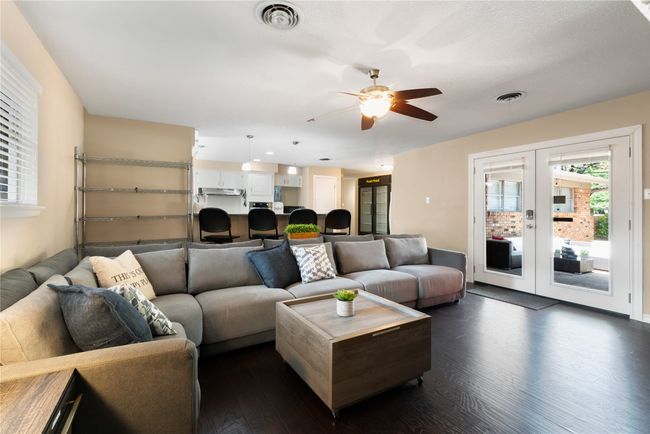Living area featuring dark wood-style flooring, french doors, and a ceiling fan | Image 5