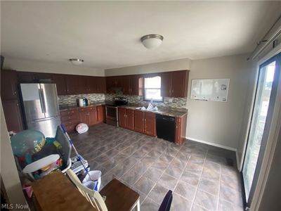 Kitchen with sink, tile patterned floors, tasteful backsplash, and stainless steel appliances | Image 3