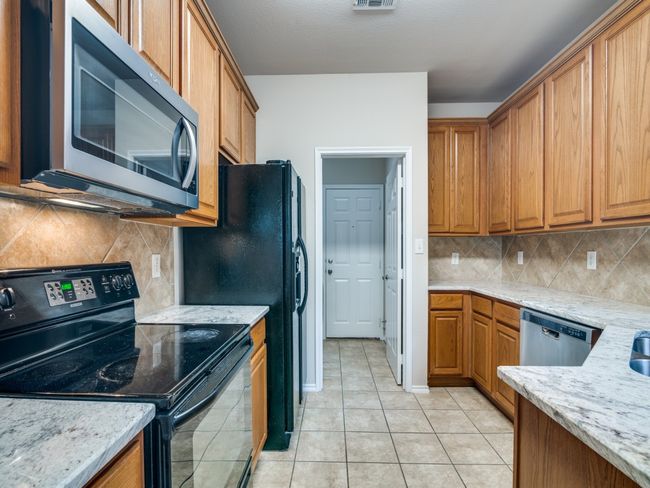 Kitchen with appliances with stainless steel finishes, brown cabinetry, and backsplash | Image 8