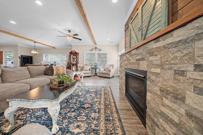 Living room with recessed lighting, a ceiling fan, wood finished floors, baseboards, and beam ceiling | Image 10