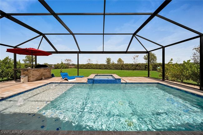 View of swimming pool with a patio area, an in ground hot tub, and glass enclosure | Image 26