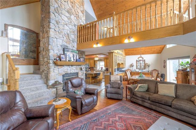 Living area featuring wood finished floors, wooden ceiling, high vaulted ceiling, and a fireplace | Image 8