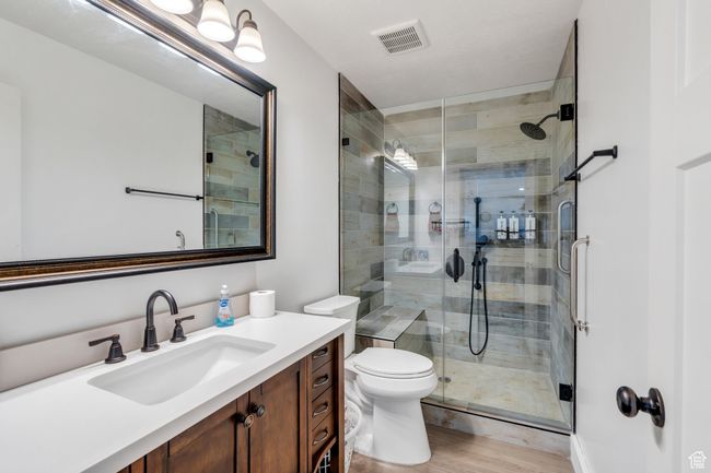 Full bathroom featuring vanity, a stall shower, and wood finished floors | Image 11