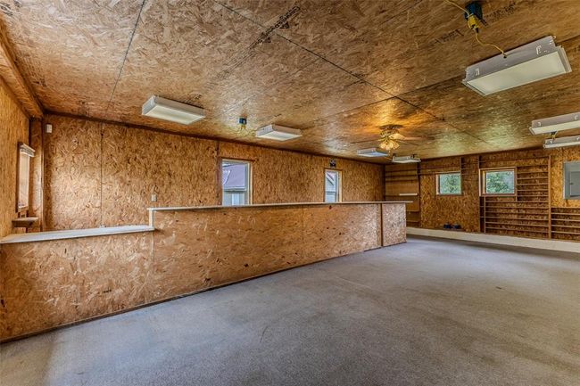 Carpeted spare room featuring healthy amount of natural light, a ceiling fan, and electric panel | Image 45