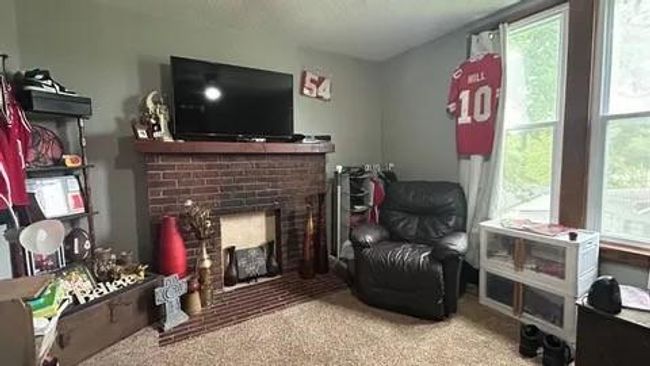 Sitting room with carpet floors, a brick fireplace, and plenty of natural light | Image 7