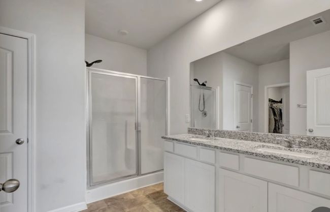 Primary bathroom gives you luxury and space with double vanities, granite countertops, step in shower, separate linen closet, separate water closet, and huge walk in closet. | Image 16