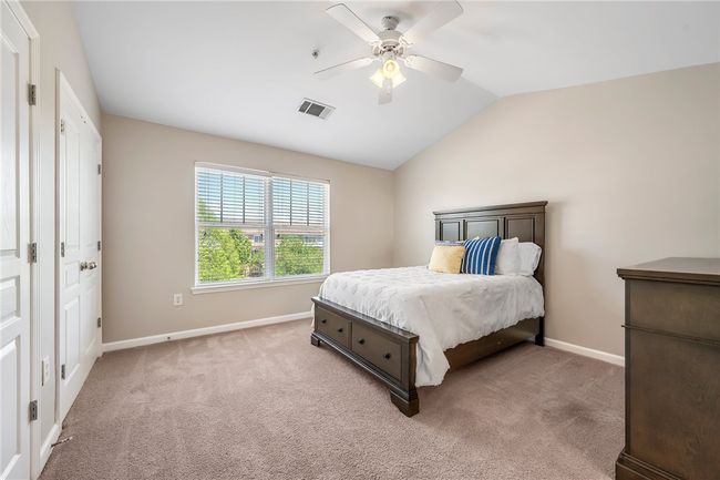 Bedroom with visible vents, light carpet, lofted ceiling, and baseboards | Image 9