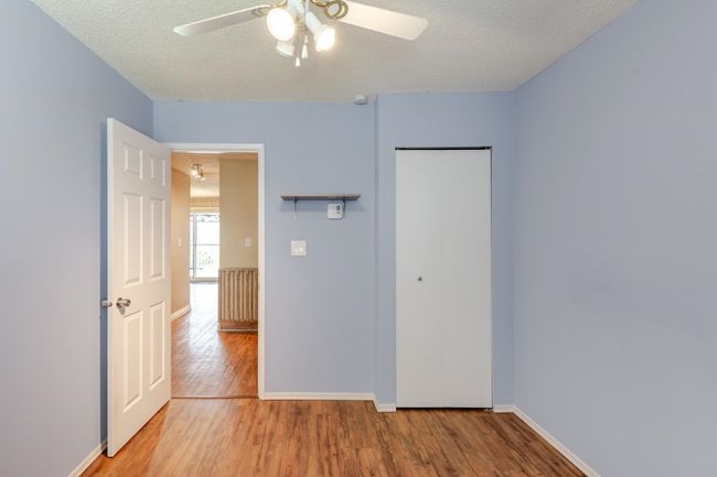 Unfurnished bedroom with a closet, baseboards, light wood-style floors, and a textured ceiling | Image 26