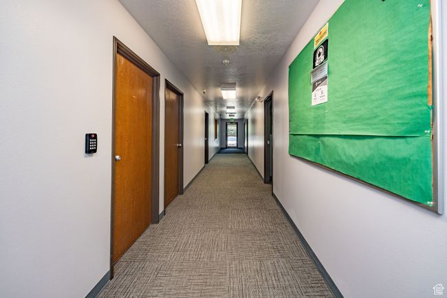 Corridor featuring carpet floors and a textured ceiling | Image 19