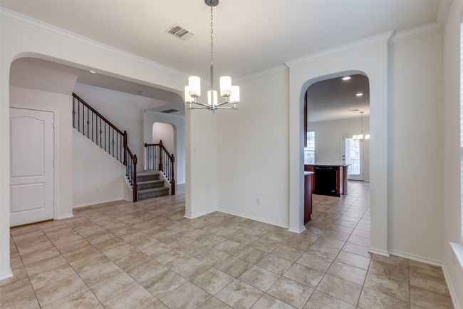 Unfurnished room with arched walkways, a notable chandelier, visible vents, and crown molding | Image 5