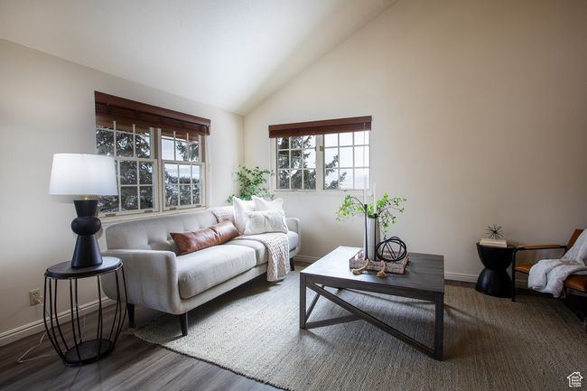 Living area with baseboards, wood finished floors, and high vaulted ceiling | Image 9