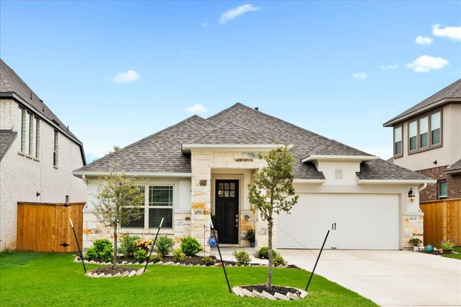 View of front of house with fence, stone siding, driveway, and a shingled roof | Image 34