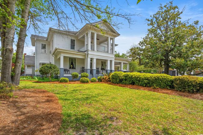 Neoclassical home featuring a balcony, a porch, and a front lawn | Image 31