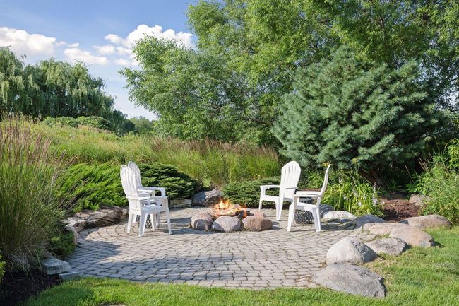 Backyard entertining includes a wood burning fireplace as well as a tucked-away fire-pit. | Image 88