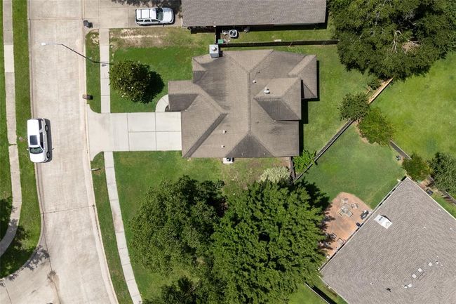 A bird’s-eye view reveals a well-maintained backyard with lush green space, mature trees, and thoughtfully added landscaping—ideal for outdoor enjoyment and gatherings. | Image 39