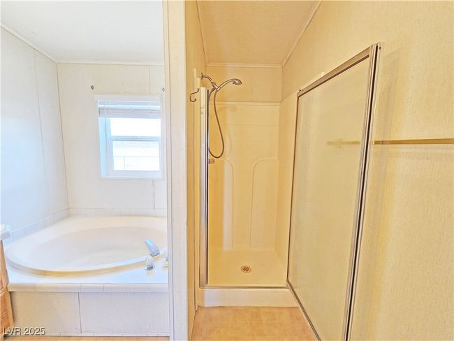 Bathroom with ornamental molding, a shower stall, and a bath | Image 26