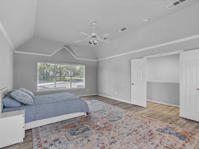 Master bedroom featuring laminated floors, vaulted ceiling, and a ceiling fan | Image 21