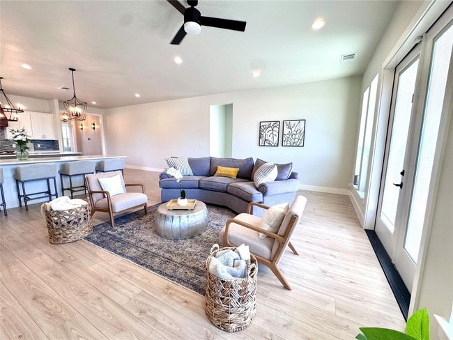 Living room featuring a chandelier, light wood-style flooring, recessed lighting, and a ceiling fan | Image 15