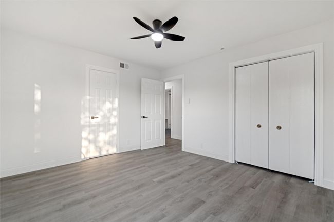 Unfurnished bedroom with ceiling fan, light wood-type flooring, and a closet | Image 24
