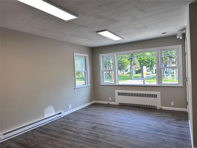 Empty room featuring radiator, a baseboard radiator, and dark wood-style floors | Image 26