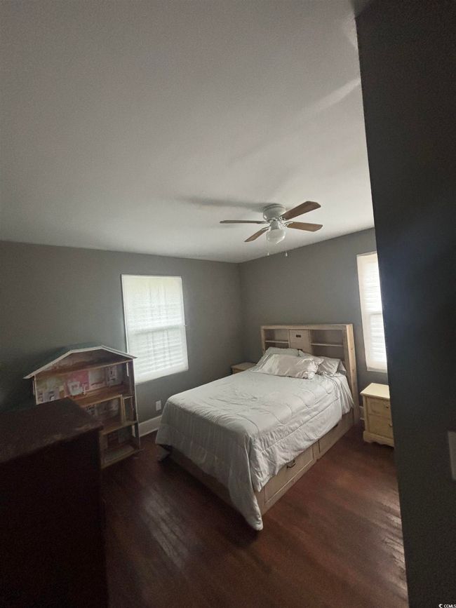 Bedroom featuring multiple windows, dark wood finished floors, and ceiling fan | Image 17