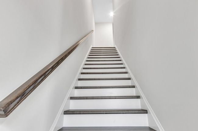 Stained hard wood stairway to the 3rd floor to the owner’s retreat, laundry room and 2nd guest room. | Image 19