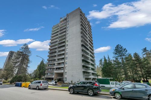 High-rise concrete building with multiple balconies, surrounded by mature trees | Card Image