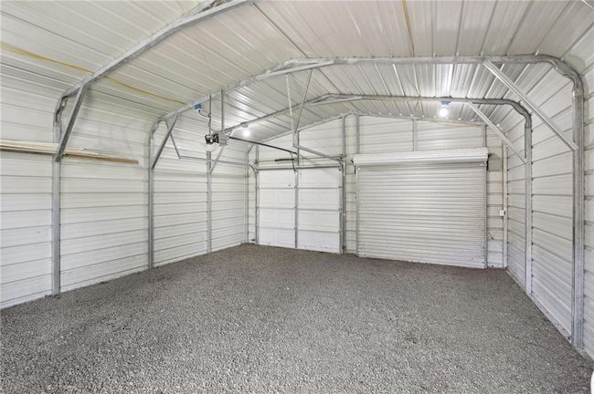 Garage featuring metal wall and a garage door opener | Image 23