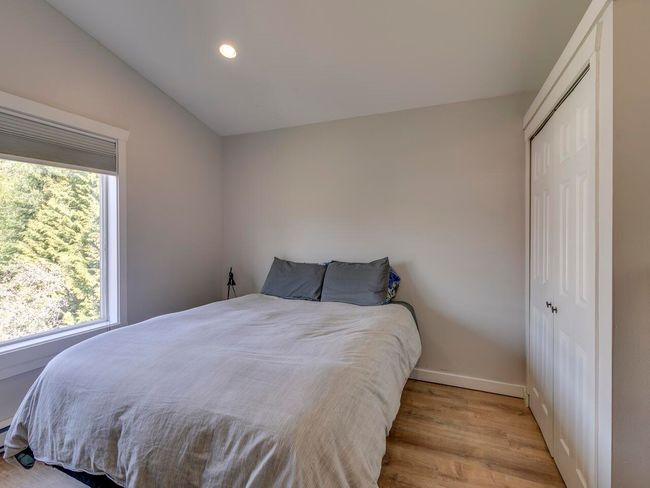 Bedroom featuring lofted ceiling, wood finished floors, multiple windows, and a closet | Image 25