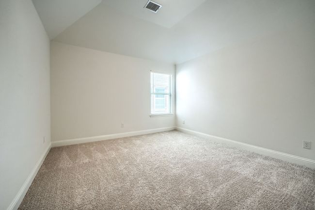 Empty room with lofted ceiling, baseboards, visible vents, and light colored carpet | Image 29