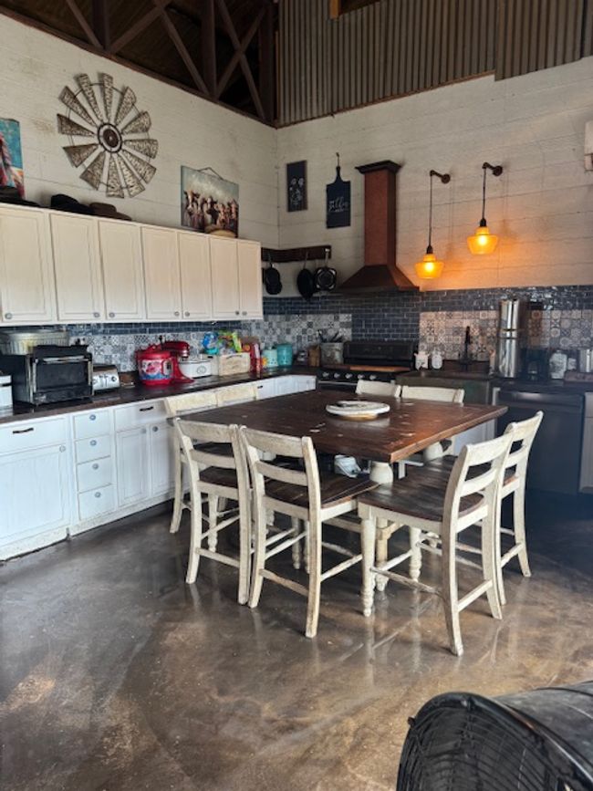 Kitchen featuring stainless steel range with electric stovetop, decorative backsplash, a towering ceiling, dark countertops, and white cabinets | Image 8