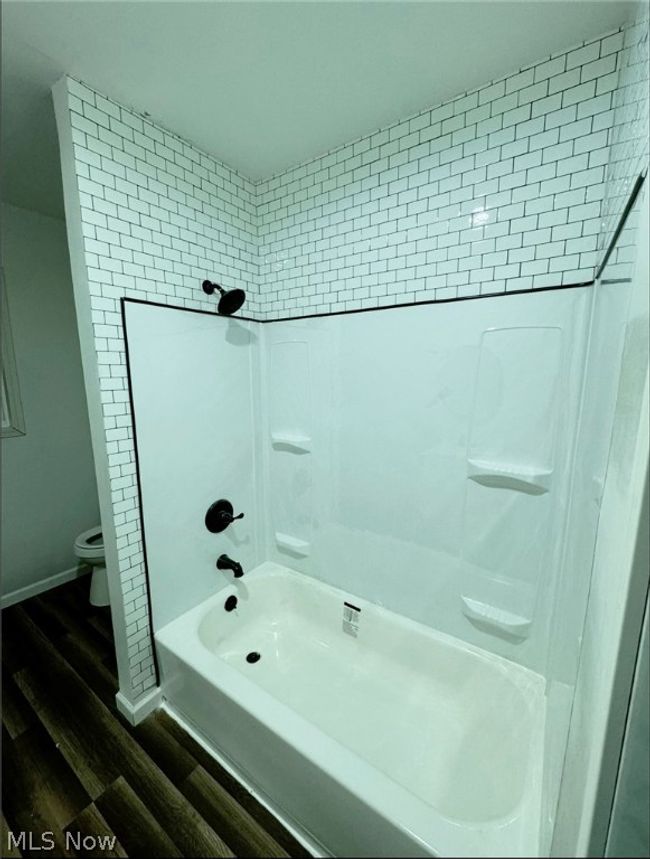 Bathroom with hardwood / wood-style floors, toilet, and tiled shower / bath combo | Image 14