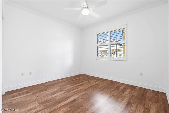 Empty room with ornamental molding, hardwood / wood-style flooring, and ceiling fan | Image 24