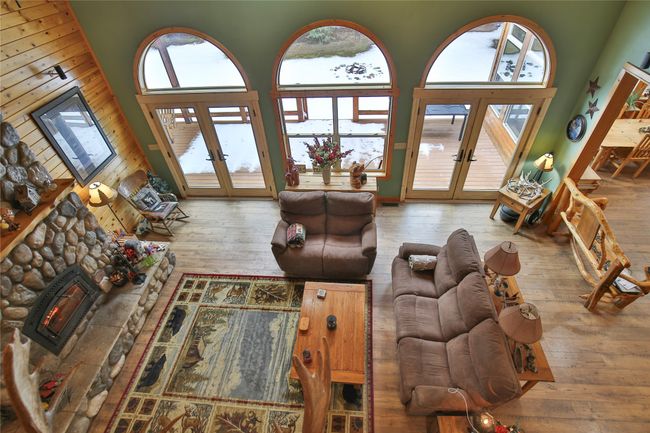 Living area featuring french doors, a fireplace, a high ceiling, and hardwood / wood-style floors | Image 40