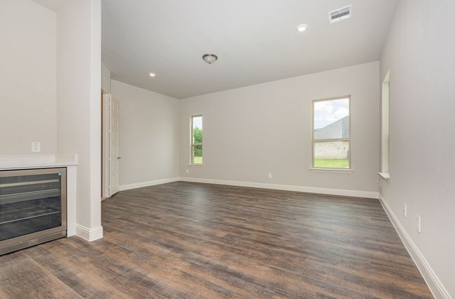Unfurnished living room with wine cooler, dark wood-style floors, baseboards, and recessed lighting | Image 19