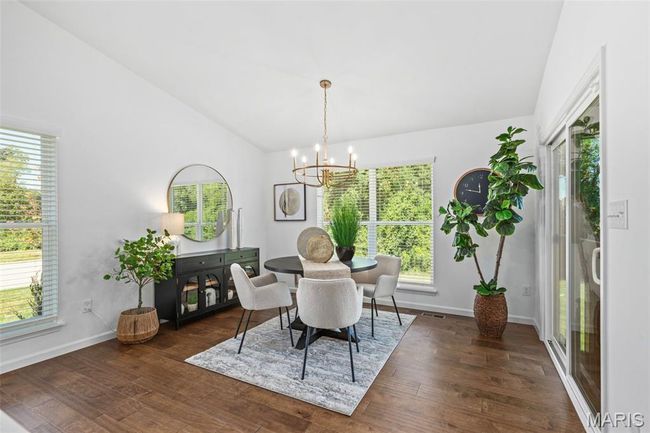 Dining space with lofted ceiling, a chandelier, dark wood-style flooring, and baseboards | Image 17