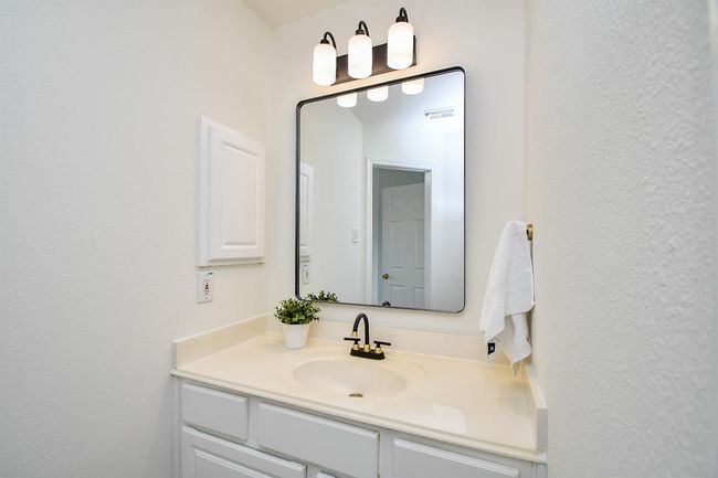 Bedroom #2 connects to a Jack and Jill bathroom, featuring separate sinks for added privacy and convenience. Note the thoughtfully selected upgrades - framed mirrors and light and plumbing fixtures. | Image 28