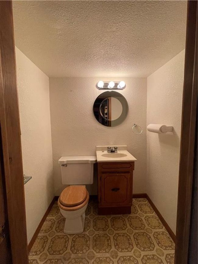 Bathroom with toilet, a textured ceiling, a textured wall, and vanity | Image 30