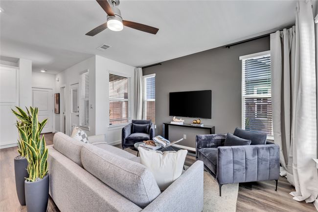 Living area with visible vents, ceiling fan, and wood finished floors | Image 4