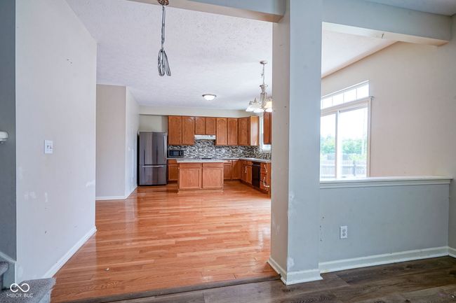 kitchen with light countertops, backsplash, light wood-style flooring, stainless steel appliances | Image 13