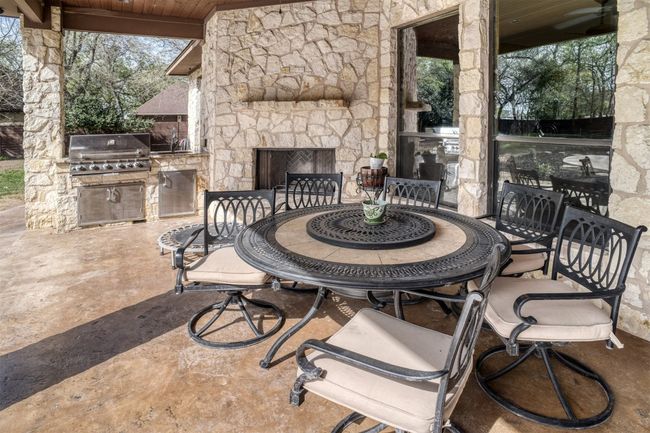 The outdoor space is amazing with a covered patio just steps from your swimming pool. Outdoor fireplace and built in BBQ grill with sink and granite counters. | Image 37