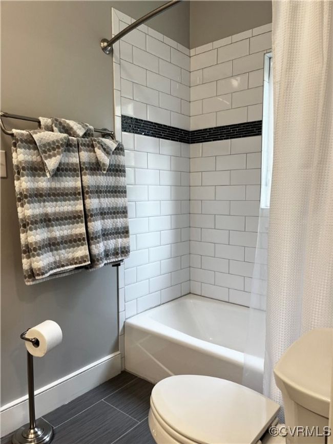 Bathroom featuring shower / bath combination with curtain and tile patterned floors | Image 21