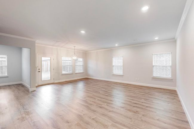 Unfurnished room with an inviting chandelier, ornamental molding, and light wood-type flooring | Image 8