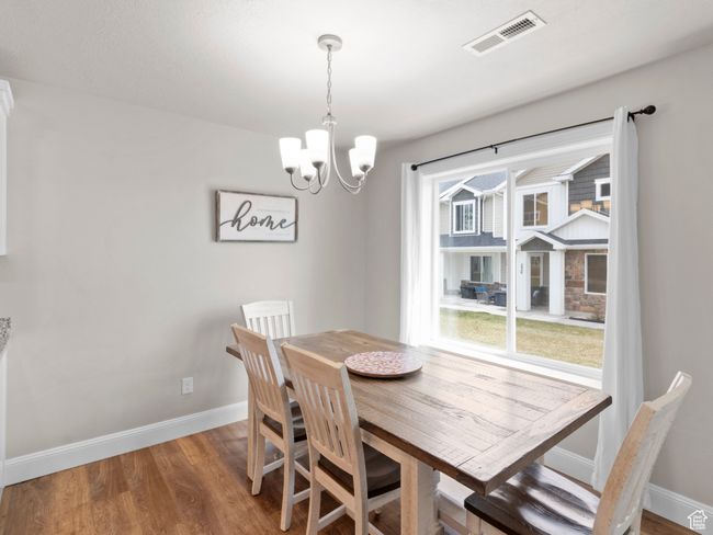 Dining room with an inviting chandelier, visible vents, light wood-style flooring, and baseboards | Image 5