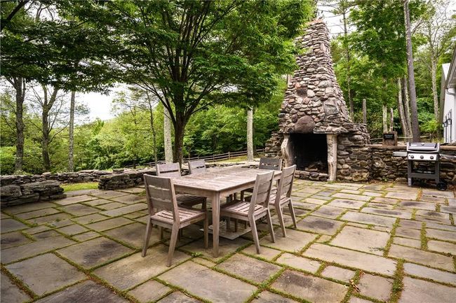 View of patio with grilling area and an outdoor stone fireplace | Image 23