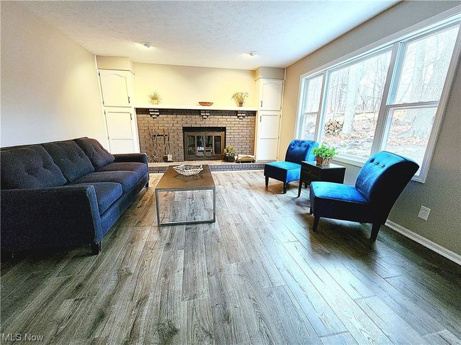 Living room featuring a textured ceiling, a fireplace, and hardwood / wood-style floors | Image 12